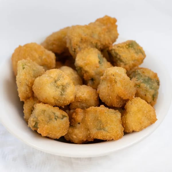 A white bowl filled with golden-brown, breaded, and deep-fried okra pieces from PoFolks.