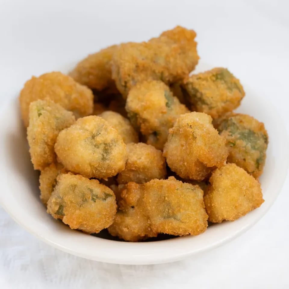 A white bowl filled with golden-brown, breaded, and deep-fried okra pieces from PoFolks.