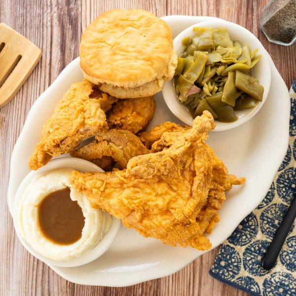 PoFolks' fried chicken meal with mashed potatoes and gravy, green beans, and a biscuit.
