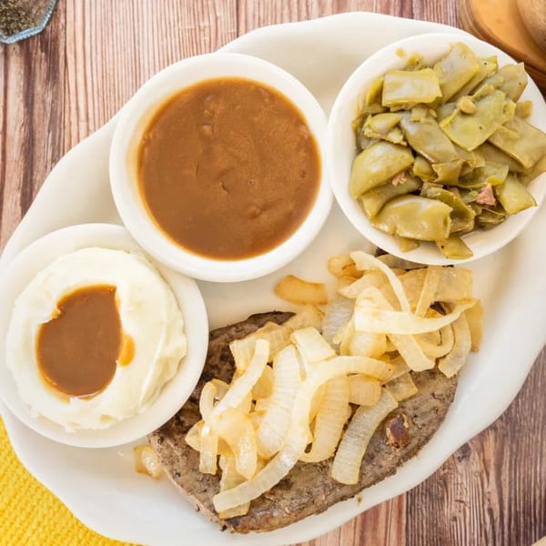 PoFolks' chopped steak with grilled onions, mashed potatoes with gravy, and green beans.