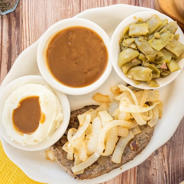 PoFolks' chopped steak with grilled onions, mashed potatoes, gravy, and green beans.